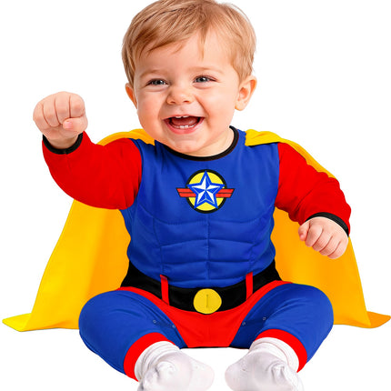 Blauw superheld babypakje met sterembleem op de borst en gele cape, zittende baby