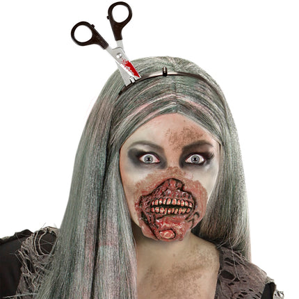 Bloederig schaar in hoofd bij zombielook met lang grijs haar, bloedspatten op het schaarblad