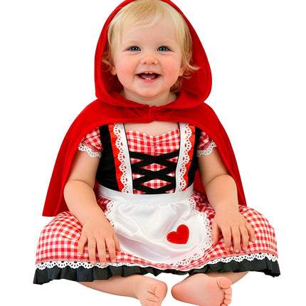 Baby in rode capelet jurk met capuchon, geruit rokje en wit schortje met rood hart