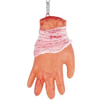 Achterkant van de bloederige hand met gaasverband om de pols en ophangoogje voor de ketting