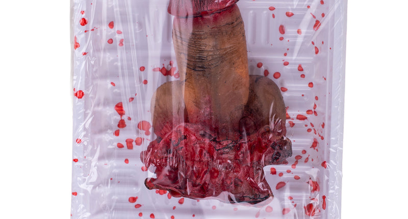 Afgehakte penis op schotel, huidkleurig nepvlees van pvc onder folie met rode bloedspatten, voor Halloween