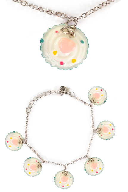 Armband cupcake met roomwitte cupcakebedeltjes, roze hartje en gekleurde spikkels aan zilverkleurig kettinkje