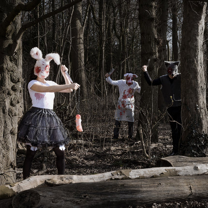 Bebloed wit schort met voorzak in een groepslook met dierenmaskers op een halloweenfeest in het bos