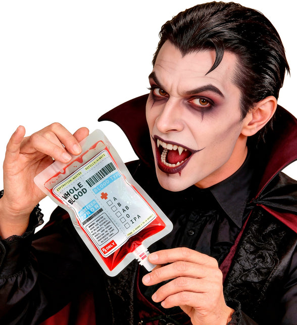 Bloedzak in de hand bij een vampierlook met cape en hoge kraag, Halloween