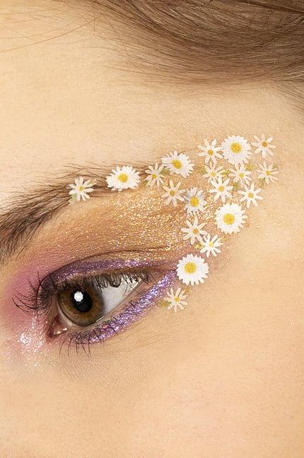 Bloemetjes in wax madeliefjes wit met geel hart geplakt rond het oog voor een flower power-look