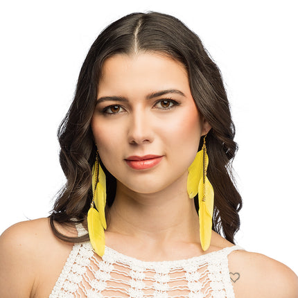 Boho veren oorbellen geel gedragen bij lang donker haar, voor een hippiefeest of festival