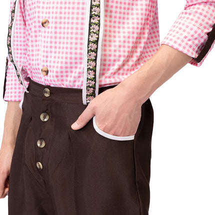 Detail van de bruine kniebroek met knoopsluiting en witte biesrand langs de zak