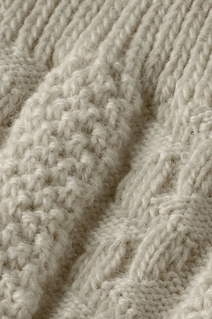 Detail van het gebreide kabel- en noppenpatroon van de off white Tiroler kniekousen