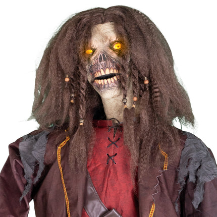Detail van het halloweenmasker met oranje oplichtende ogen, tandenrij en dreadlocks met kralen