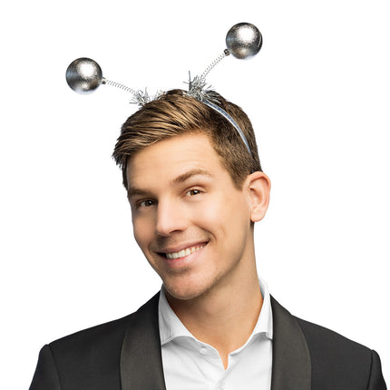 Diadeem Globe zilver met twee glanzende bollen op spiraalveren en zilveren folie aan de basis, gedragen door een man