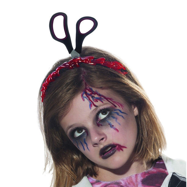Diadeem schaar door hoofd gedragen met rode bloedrand op de band en griezelschmink voor Halloween