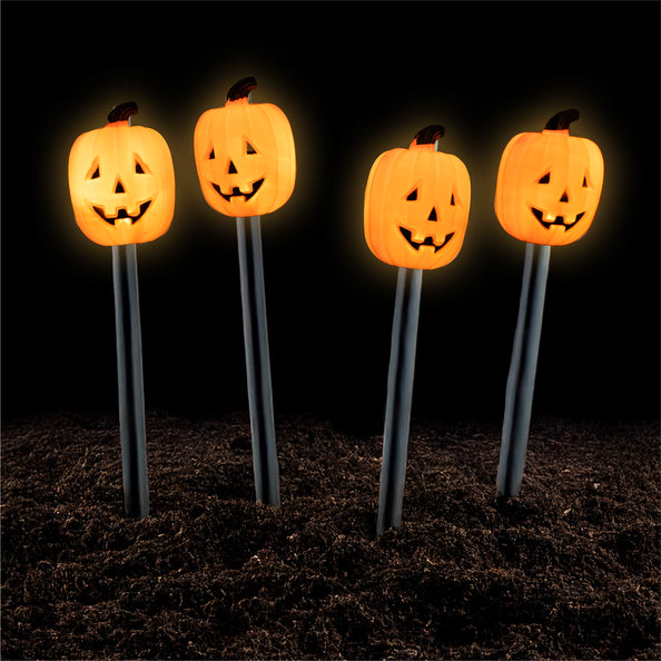 Tuinverlichting pompoenen 4 stuks brandend in de aarde met oranje gloed en uitgesneden gezichtjes voor Halloween