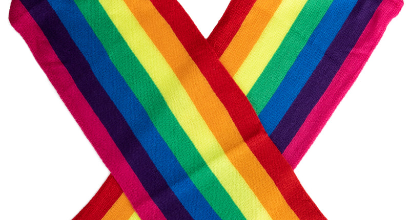 Gebreide regenboogsjaal met zeven kleurbanen en franjes, gekruist gelegd, voor Pride