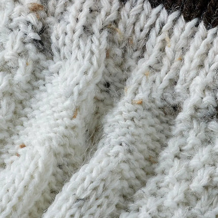 Gespikkeld wit breiwerk met ribstructuur, detail van de tiroler beenwarmer