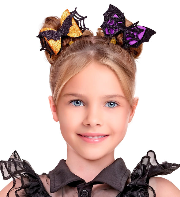 Haarclips vleermuis en spinnenweb in twee knotjes bij zwarte jurk voor Halloween