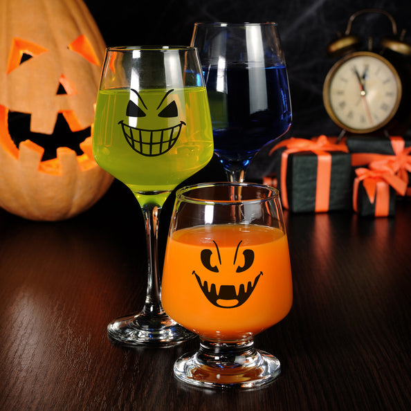 Halloween glasstickers met zwarte griezelgezichten op een wijnglas en bierglas voor Halloween