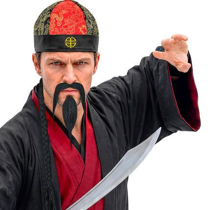 Heer met chinese hoed, hangsnor en puntsik in een krijgsheerlook op een themafeest