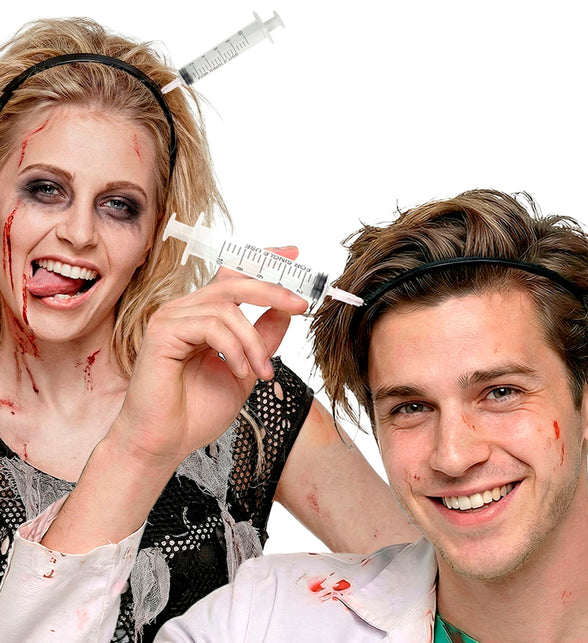 Injectienaald door hoofd gedragen door zombiepaar met bloedschmink tijdens Halloween