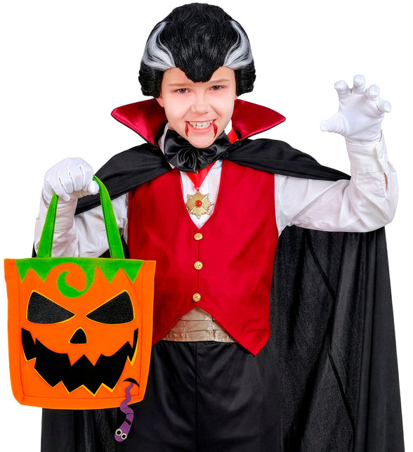 Jongen draagt oranje pompoentas aan groene hengsels tijdens trick or treat