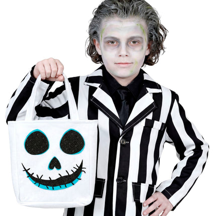 Jongen draagt spooktas aan de stoffen hengsels bij een zwart-wit gestreept Halloweenkostuum