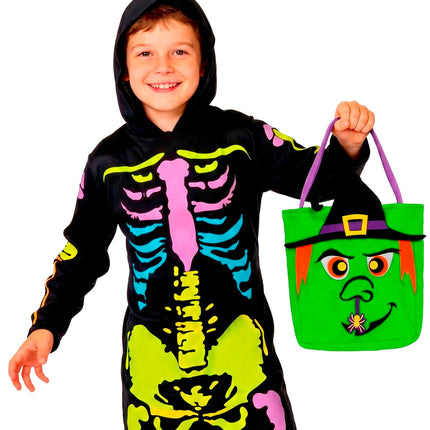 Jongen houdt de groene trick-or-treat tas met heksengezicht in de hand