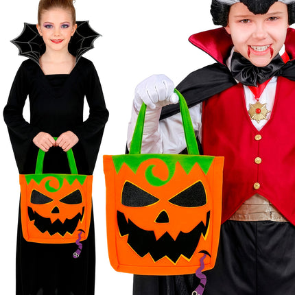 Kinderen met trick-or-treat tas pompoen bij vampier- en heksenoutfit op Halloween