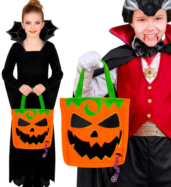 Kinderen met trick-or-treat tas pompoen bij vampier- en heksenoutfit op Halloween
