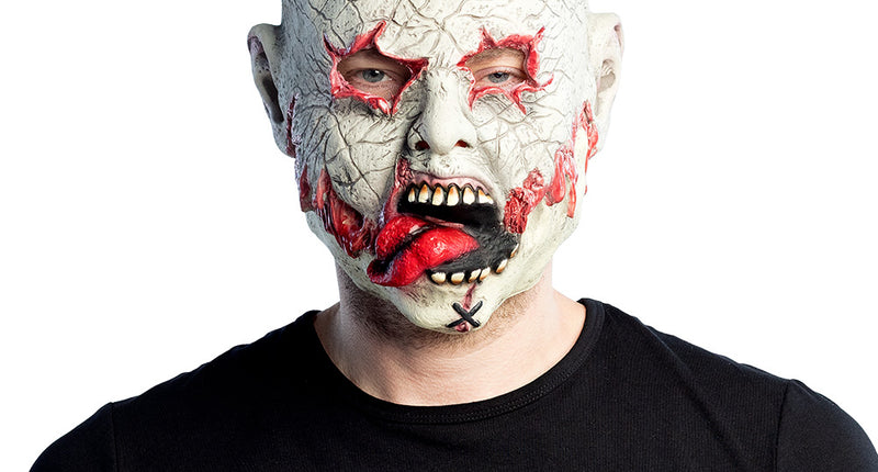 Latex hoofdmasker Undead gedragen door man, bleek zombiehoofd met open wonden en rode tong, voor Halloween