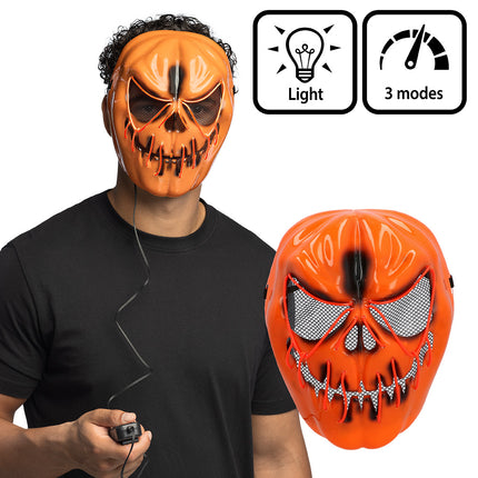 LED masker Pompoen Halloween gedragen bij een zwart shirt, met het batterijkastje aan het snoer in de hand