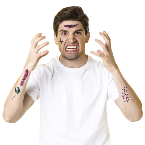 Man met Halloween tattoos van nepwonden op voorhoofd, wang en beide onderarmen voor een zombielook