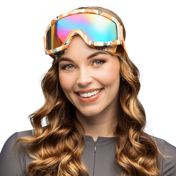 Party skibril Blitz oranje op het voorhoofd geschoven bij een vrouw, met regenboogglas, voor een après-skifeest