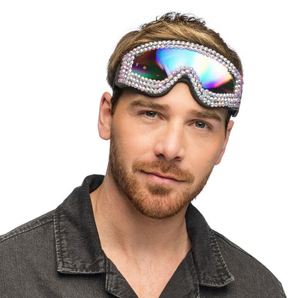Party skibril La folie omhooggeschoven gedragen door een man, strass glinstert rond het regenboogvizier