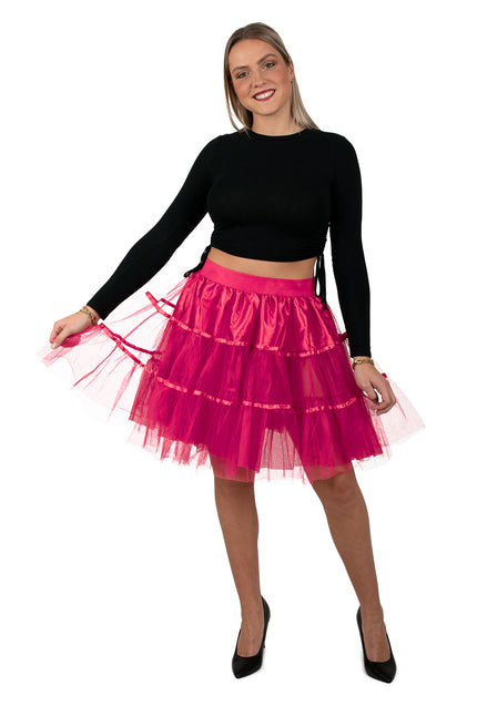 Petticoat neonroze voor dames, felroze tulerok van 45 cm met satijnen bandjes, gedragen bij een zwart topje