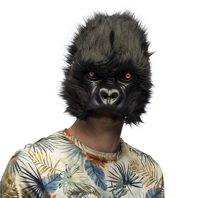 Pluchen halfmasker gorilla in zwart met pluizige vacht en amberkleurige ogen, gedragen op een themafeest