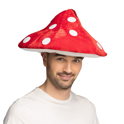 Rode paddenstoelenhoed met witte stippen op een man in wit shirt, voor carnaval
