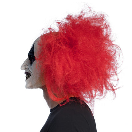 Ruddy clown hoofdmasker van zijkant gedragen, kromme neus en rood haar tot in de nek