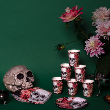 Servetten Day of the Dead op de gedekte halloweentafel bij bekers en bordje met schedelprint
