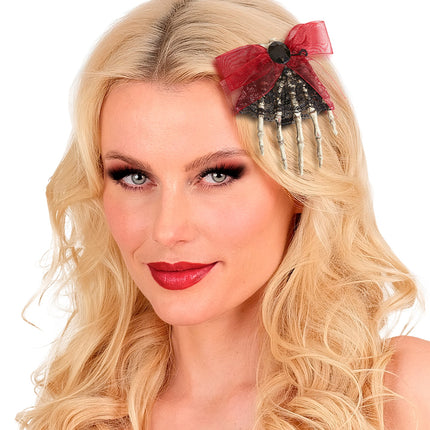 Skelet broche dode hand in blond haar, vingers naar beneden met rode strik, voor dames op Halloween