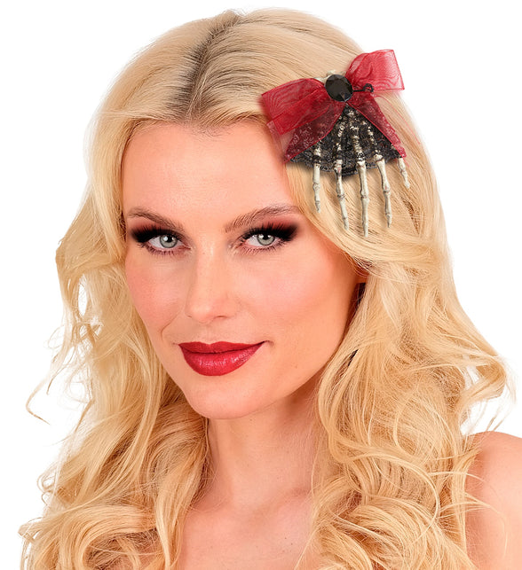 Skelet broche dode hand in blond haar, vingers naar beneden met rode strik, voor dames op Halloween