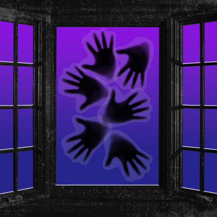 Spook handen stickers op een verlicht raam als halloweendecoratie in het donker