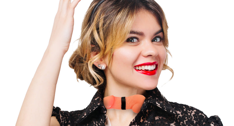 Strik met penis in huidkleur gedragen op de kraag van een zwarte kanten blouse tijdens een vrijgezellenfeest