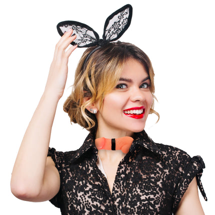 Strik met penis in huidkleur gedragen op de kraag van een zwarte kanten blouse tijdens een vrijgezellenfeest