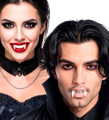 Vampiertanden glow in the dark gedragen door een dame met rode lippen en een heer in zwart, voor Halloween