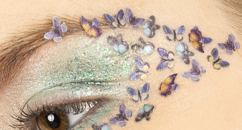 Vlinderglitters in wax op het ooglid, paarse en gele vlindertjes uitlopend naar de slaap voor een themafeest