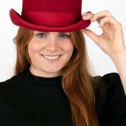 Vrouw met rode hoge hoed van wolvilt op een themafeest, hand aan de rand