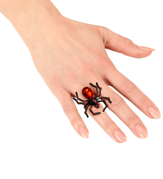 Ring spin met rode edelstenen gedragen op de vinger, zwarte poten over de hand